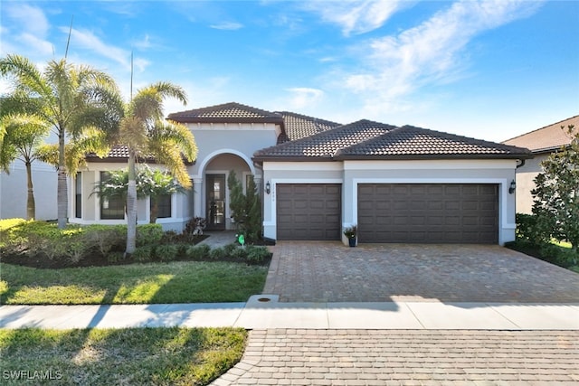 mediterranean / spanish-style home featuring a garage and a front lawn