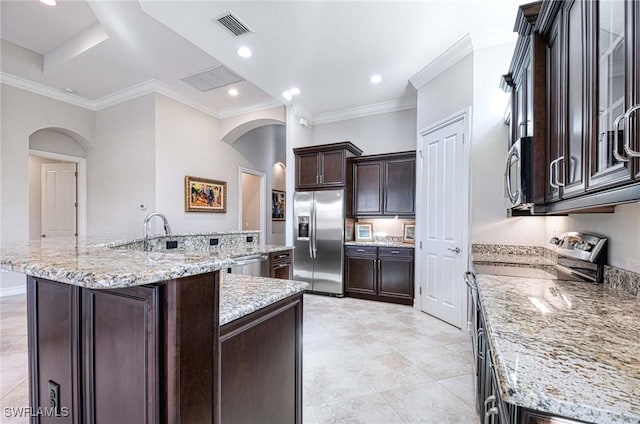 kitchen featuring light stone counters, an island with sink, and appliances with stainless steel finishes