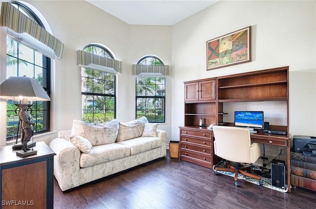 office area featuring a towering ceiling and dark hardwood / wood-style floors