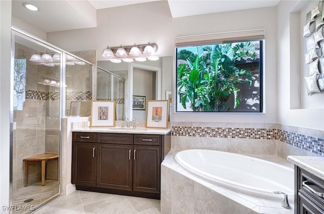 bathroom with tile patterned floors, vanity, and independent shower and bath