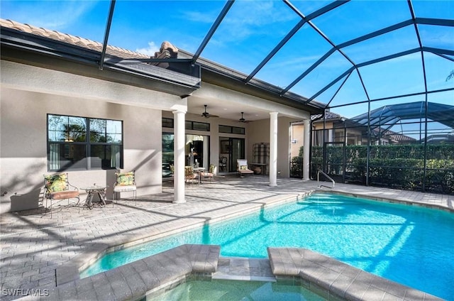 view of swimming pool featuring an in ground hot tub, ceiling fan, a lanai, and a patio area