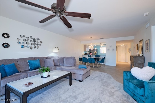 living room featuring ceiling fan with notable chandelier