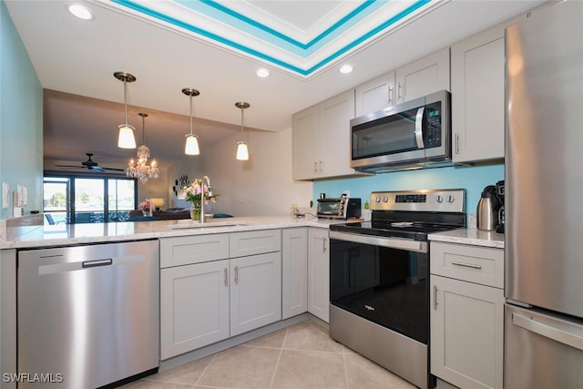 kitchen featuring pendant lighting, light tile patterned floors, appliances with stainless steel finishes, white cabinets, and kitchen peninsula