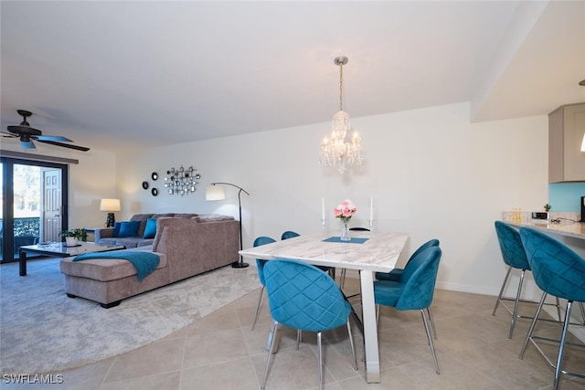 tiled dining room featuring ceiling fan with notable chandelier