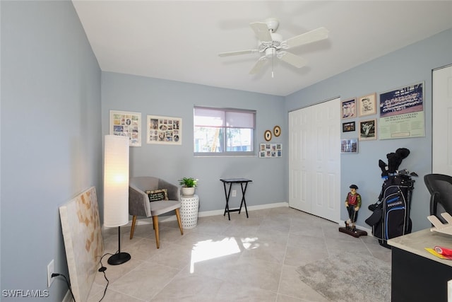 sitting room featuring light tile patterned flooring and ceiling fan