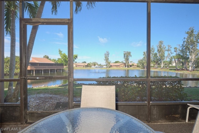 sunroom / solarium featuring a water view