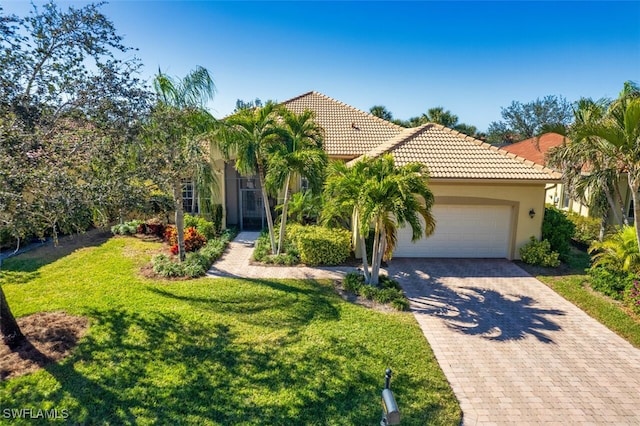 mediterranean / spanish house featuring a garage and a front lawn