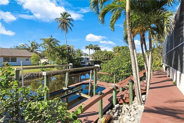 dock area with a lanai and a water view