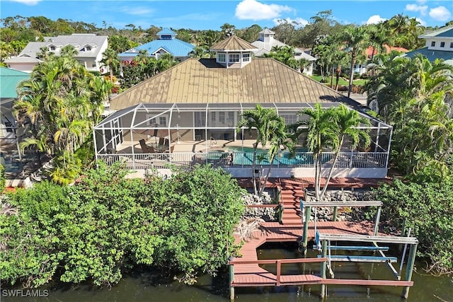 back of house featuring a water view and a lanai