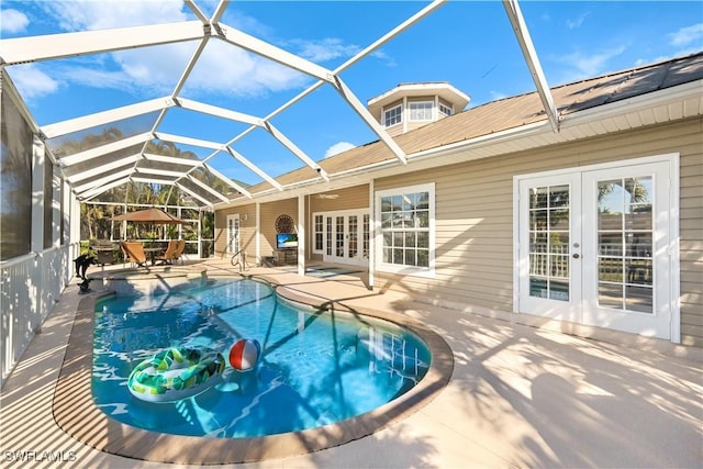 view of pool with french doors, glass enclosure, and a patio