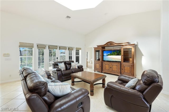 living room with french doors, light tile patterned flooring, high vaulted ceiling, and a skylight