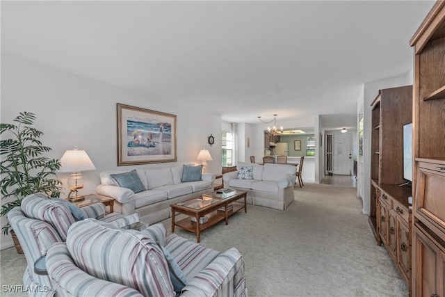 carpeted living room featuring an inviting chandelier