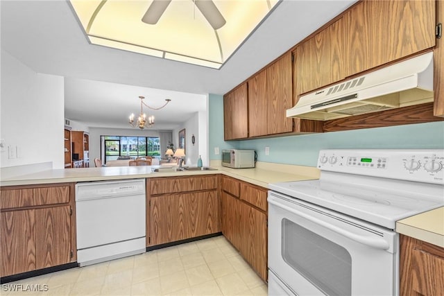 kitchen with sink, ceiling fan with notable chandelier, and white appliances