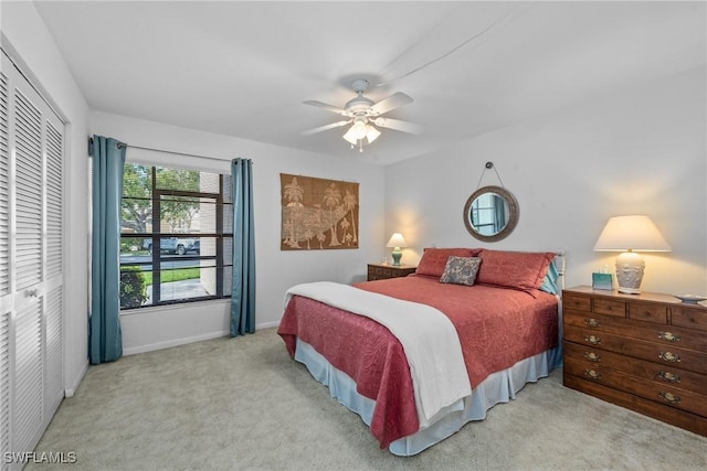 bedroom featuring light colored carpet, a closet, and ceiling fan