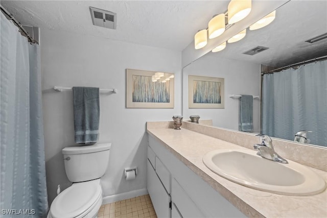 bathroom with vanity, toilet, and a textured ceiling