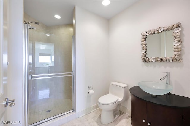 bathroom with vanity, a shower with shower door, and toilet