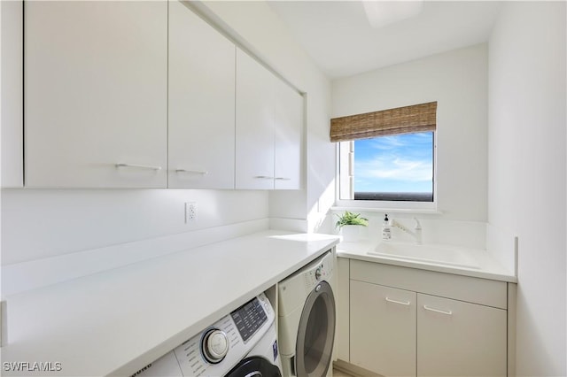 washroom with sink, washing machine and dryer, and cabinets