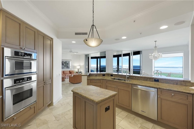 kitchen with pendant lighting, stainless steel appliances, sink, and a kitchen island