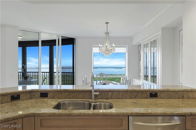 kitchen with sink, hanging light fixtures, ornamental molding, stainless steel dishwasher, and an inviting chandelier