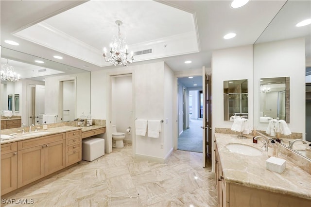 bathroom featuring vanity, a notable chandelier, a tray ceiling, ornamental molding, and toilet