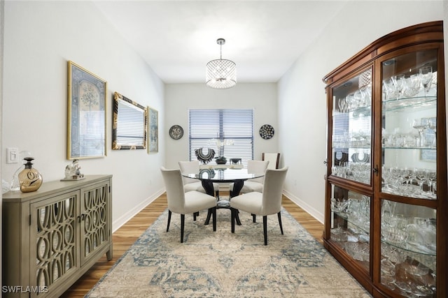 dining space with wood-type flooring and a chandelier