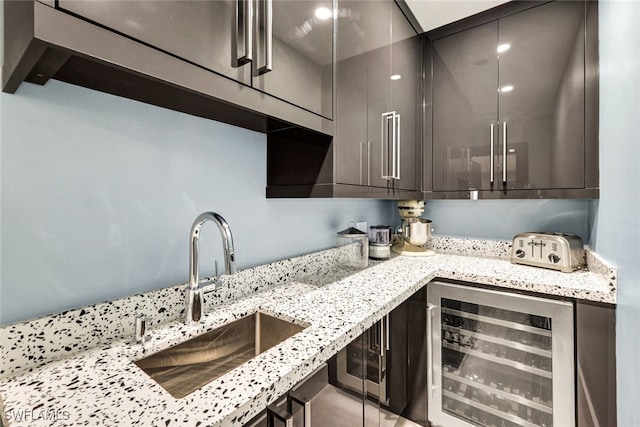 13 Pelican St W, Naples, FL 34113 - kitchen with light stone counters, sink, and beverage cooler