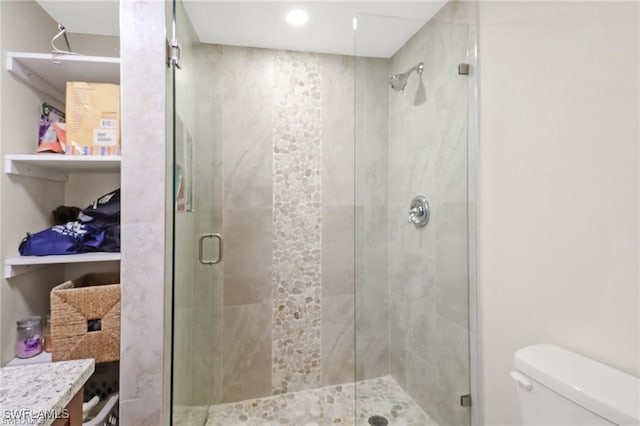 bathroom with toilet and a shower with shower door