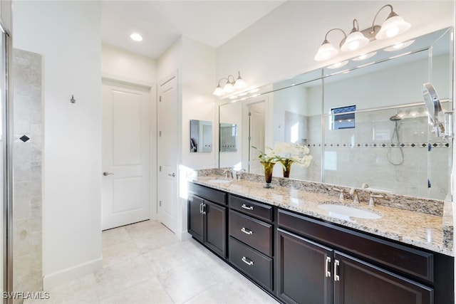 bathroom with vanity, tile patterned flooring, and a tile shower