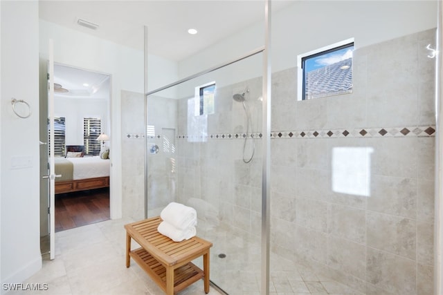 bathroom with tile patterned flooring and tiled shower