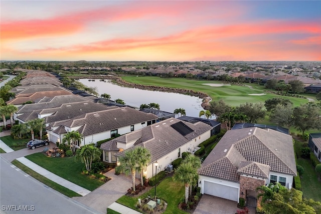 aerial view at dusk featuring a water view