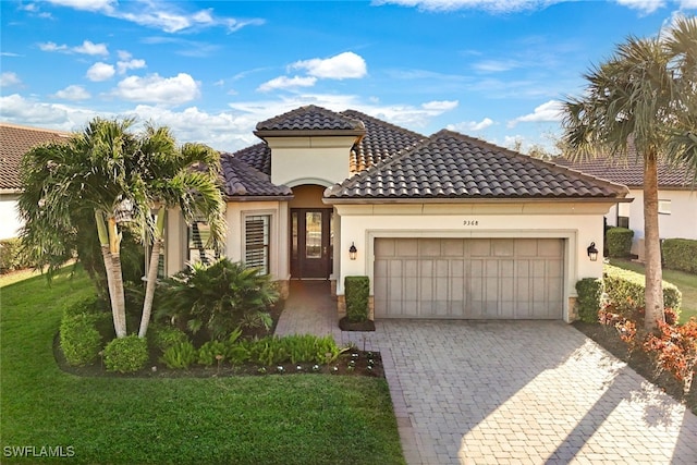 mediterranean / spanish-style home featuring a garage and a front yard