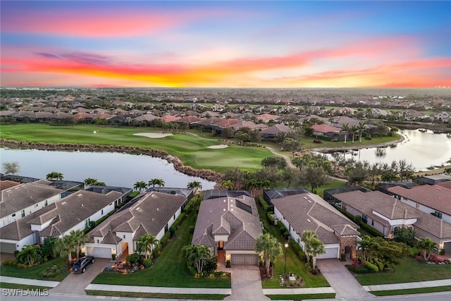 aerial view at dusk featuring a water view