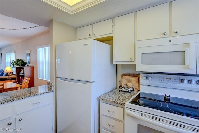 kitchen with light stone countertops, white cabinets, and white appliances