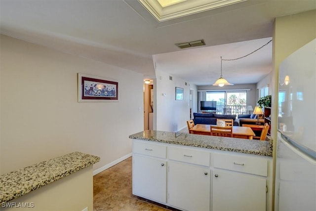 kitchen with white refrigerator, white cabinetry, and decorative light fixtures