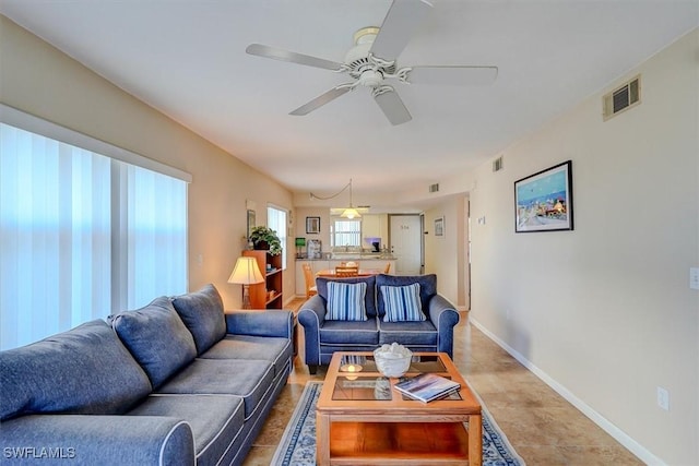 tiled living room featuring ceiling fan