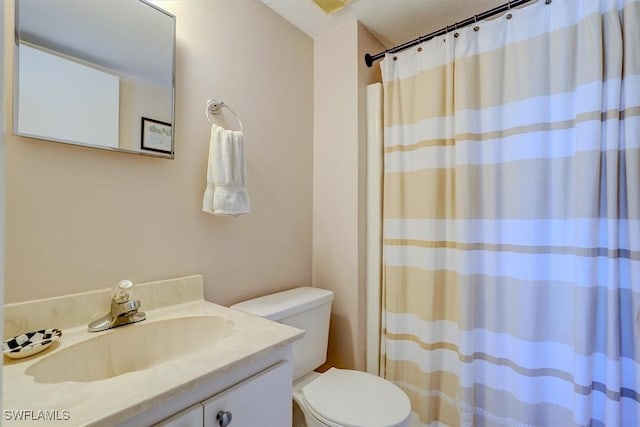 bathroom with vanity, walk in shower, and toilet