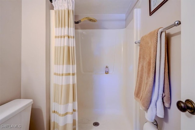 bathroom with a shower with curtain and toilet