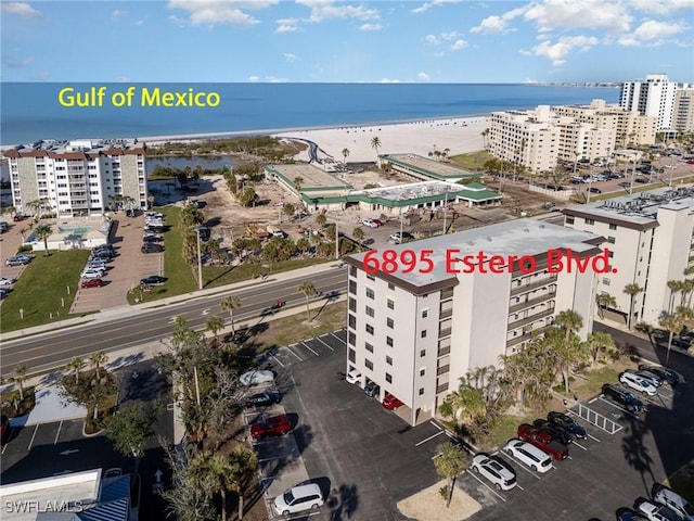 birds eye view of property with a water view and a view of the beach