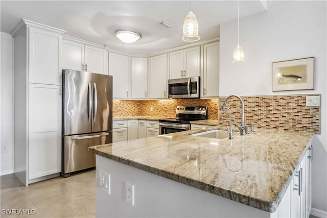 kitchen with sink, decorative light fixtures, appliances with stainless steel finishes, kitchen peninsula, and white cabinets