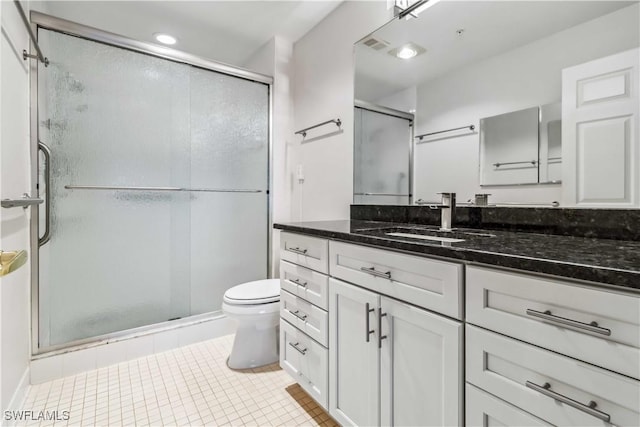 bathroom featuring vanity, tile patterned floors, toilet, and walk in shower