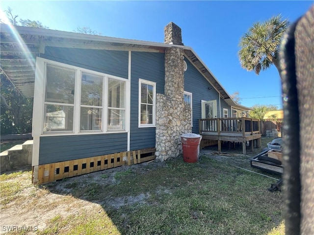 view of home's exterior featuring a lawn and a deck