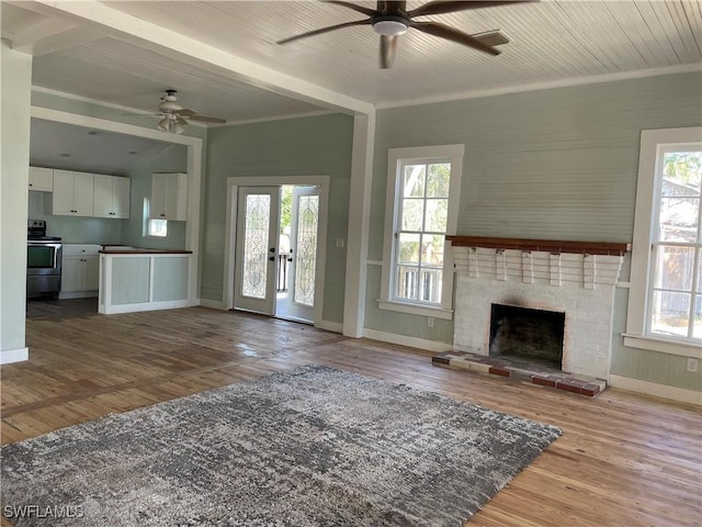 unfurnished living room with hardwood / wood-style flooring, a brick fireplace, wood ceiling, and ceiling fan