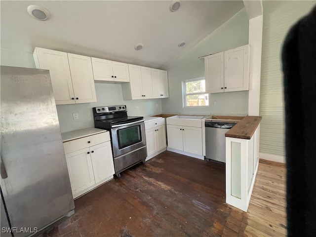 kitchen featuring butcher block counters, vaulted ceiling, dark hardwood / wood-style floors, stainless steel appliances, and white cabinets