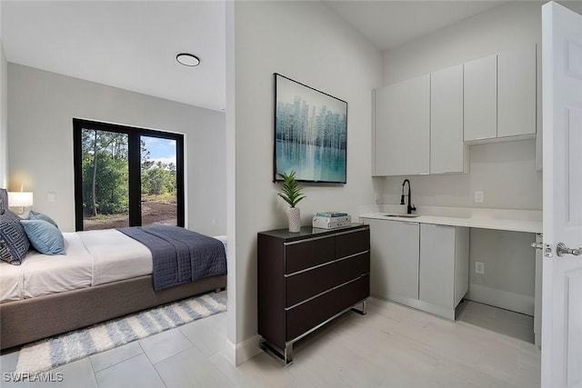 bedroom with a sink and baseboards