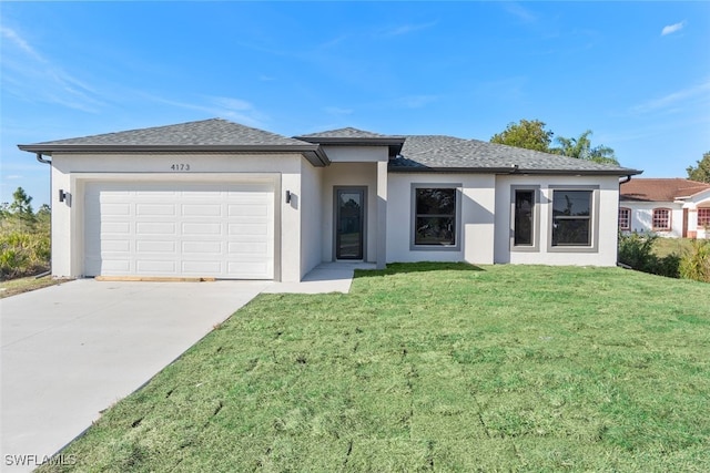 prairie-style home with a front yard, driveway, an attached garage, and stucco siding