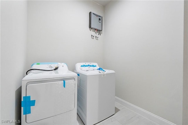 washroom featuring washer and dryer, laundry area, and baseboards