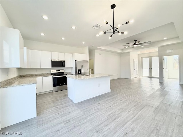 kitchen with a kitchen island, appliances with stainless steel finishes, pendant lighting, sink, and white cabinets