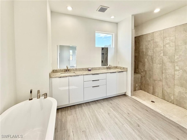 bathroom with vanity, plus walk in shower, and hardwood / wood-style floors