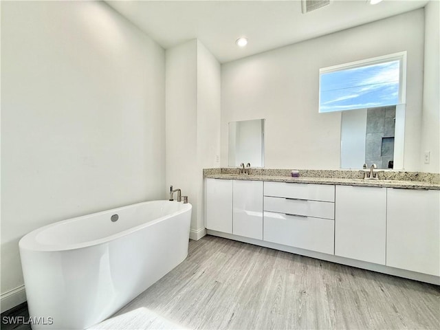 bathroom with vanity, independent shower and bath, and wood-type flooring