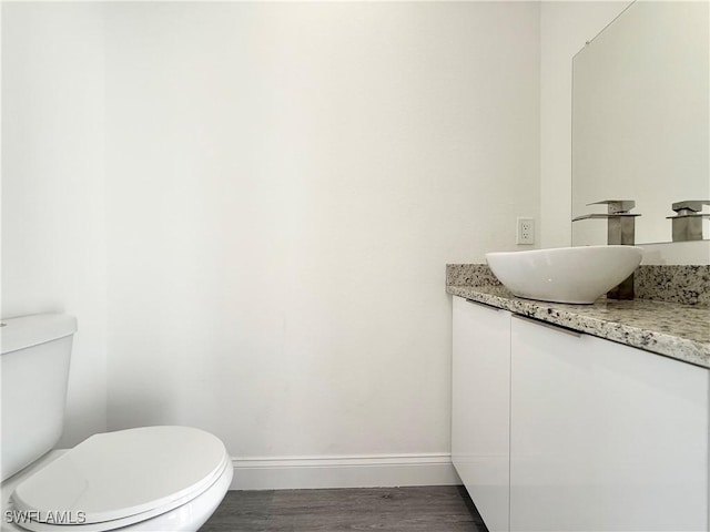 bathroom featuring vanity, wood-type flooring, and toilet